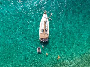 Yacht Sailing: Aerial view of a sailing yacht in clear waters